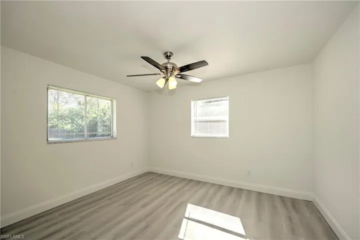 Unfurnished room with ceiling fan and light wood-type flooring