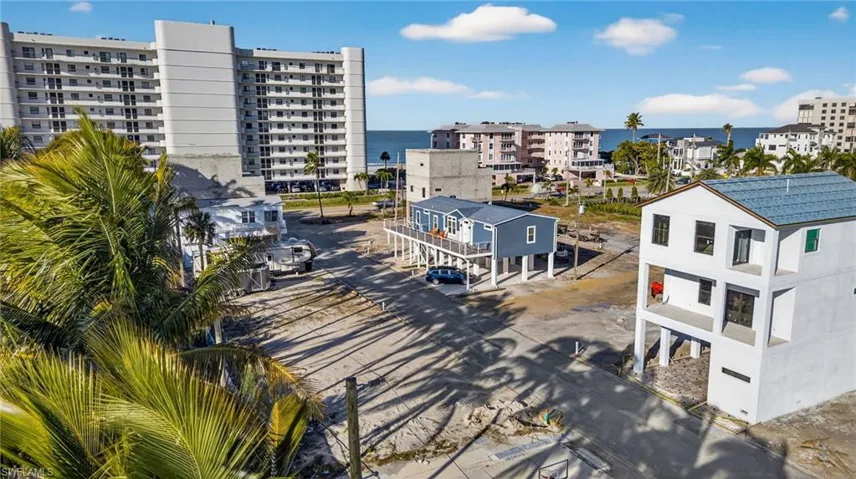 Elevated coastal structures featuring metal roof systems, exterior siding, and open-foundation designs situated near the shoreline