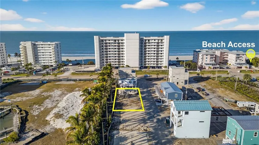 Vacant residential lot featuring direct proximity to the coastline and established palm tree landscaping