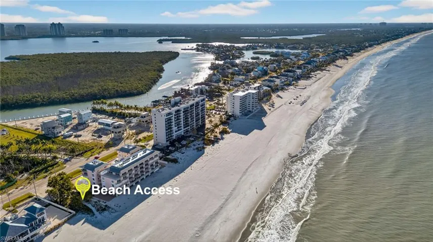 Aerial coastal perspective featuring direct shoreline proximity, expansive sandy beach, and unobstructed ocean frontage