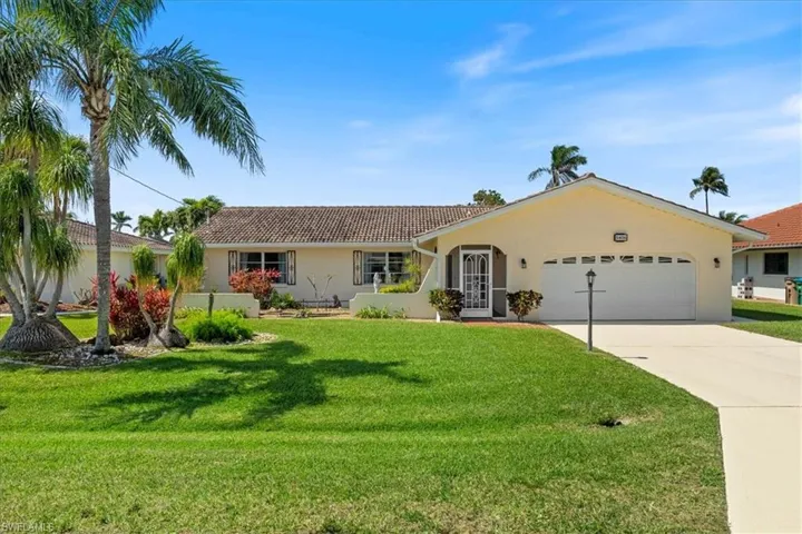 Single story home featuring stucco siding, driveway, a front lawn, a tile roof, and an attached garage