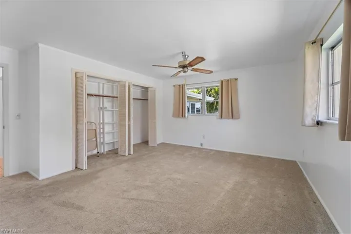 Unfurnished bedroom featuring baseboards, ceiling fan, ornamental molding, carpet floors, and a closet