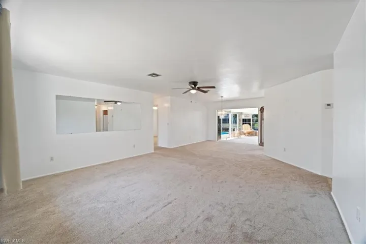 Spare room featuring a ceiling fan, carpet, and visible vents