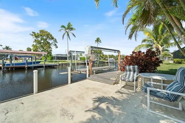View of dock with boat lift and a water view