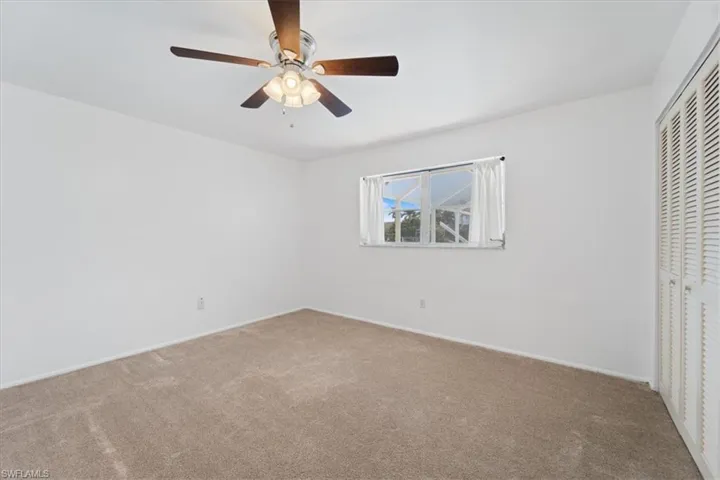 Unfurnished bedroom featuring a ceiling fan, a closet, and carpet floors