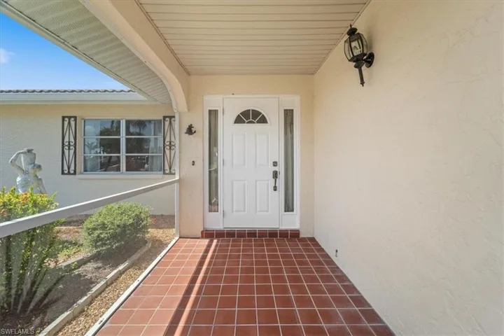 Doorway to property featuring stucco siding