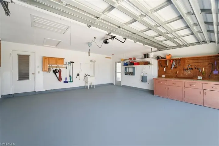 Garage featuring a sink, a workshop area, and a garage door opener