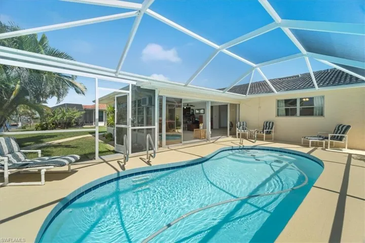 Outdoor pool featuring a patio area and glass enclosure