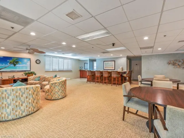 Living room with a paneled ceiling, ceiling fan, and carpet floors