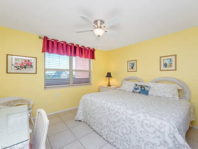 Tiled bedroom featuring ceiling fan