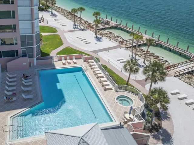 View of swimming pool with a hot tub, a water view, and a patio
