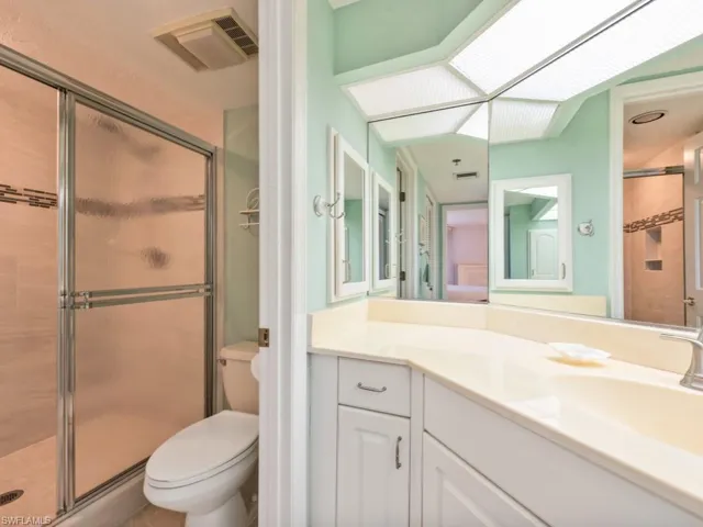 Bathroom with walk in shower, toilet, and vanity