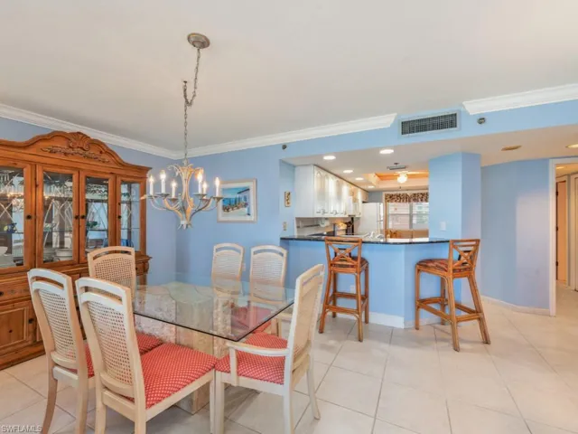 Dining room featuring an inviting chandelier, light tile floors, and crown molding