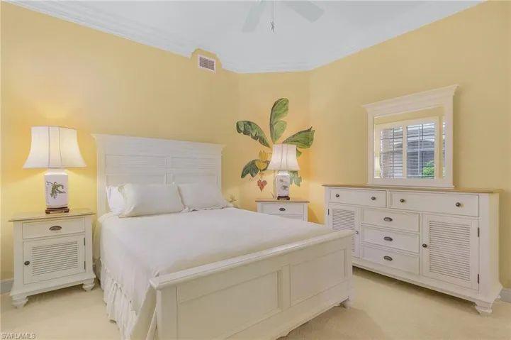 Bedroom with light carpet, ornamental molding, and ceiling fan