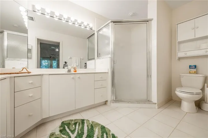 Bathroom with vanity, tile patterned floors, and a stall shower