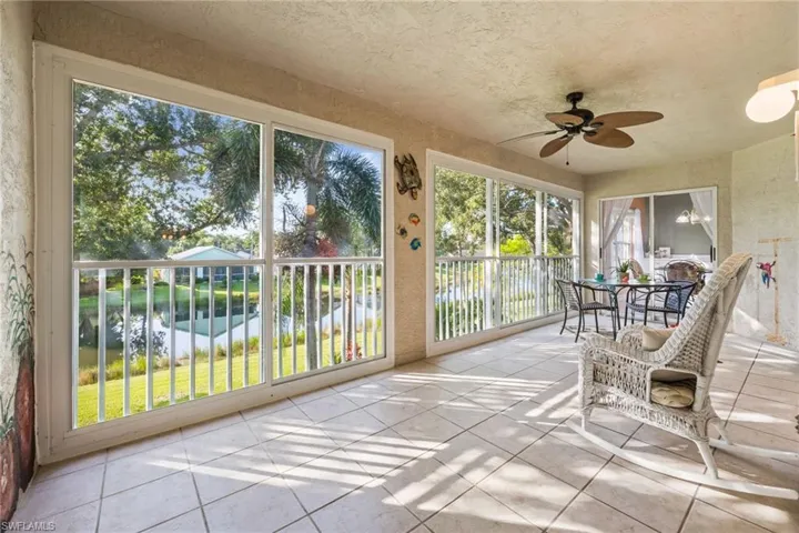 Sunroom with a water view and tile patterned flooring