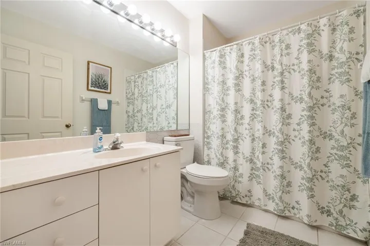 Bathroom with tile patterned flooring, vanity and a shower