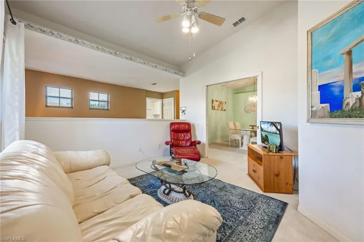 Den/extra bedroom featuring a ceiling fan, carpet, and vaulted ceiling