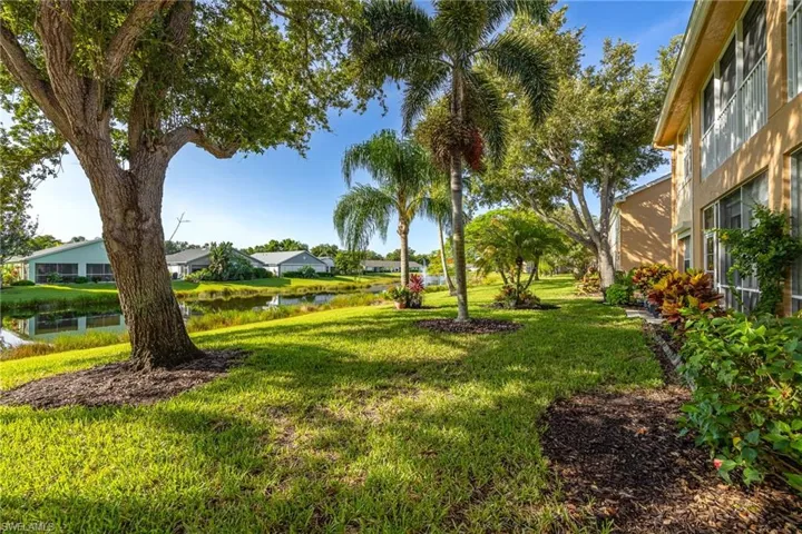 View of green lawn featuring a water view and a residential view