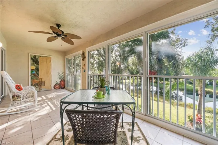 Sunroom / solarium featuring a ceiling fan and a water view