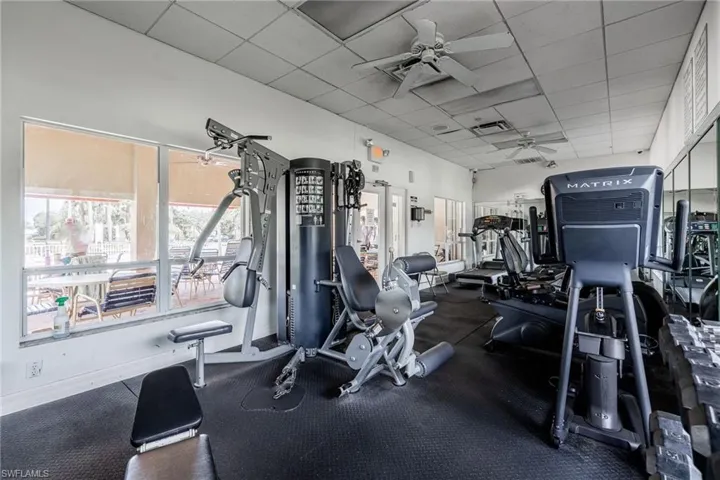 Community workout area with a ceiling fan and a drop ceiling