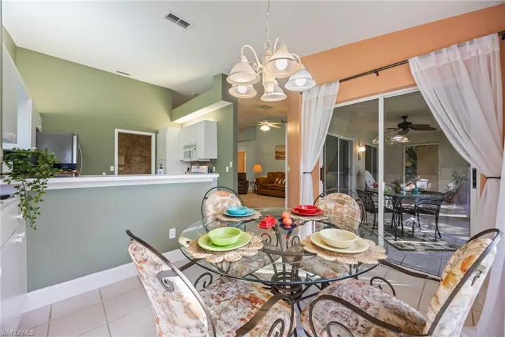Dining space featuring ceiling fan, tile patterned flooring, and a chandelier