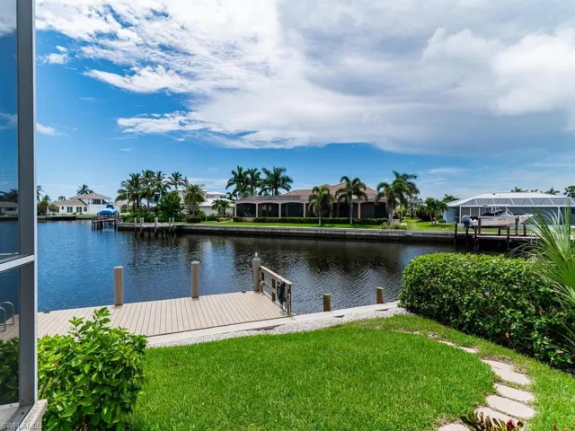 View of dock with a water view and a yard