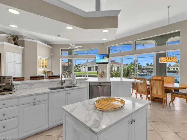 Kitchen featuring a kitchen island, dishwasher, ceiling fan, and decorative light fixtures