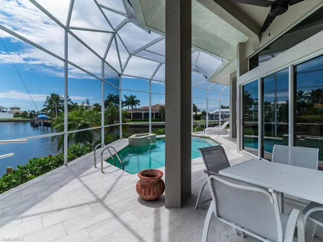 View of pool with a lanai, a water view, and a patio area