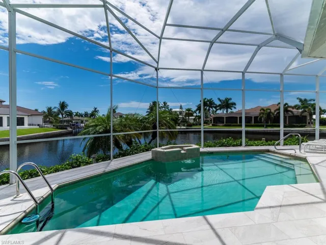 View of swimming pool featuring a water view and a lanai