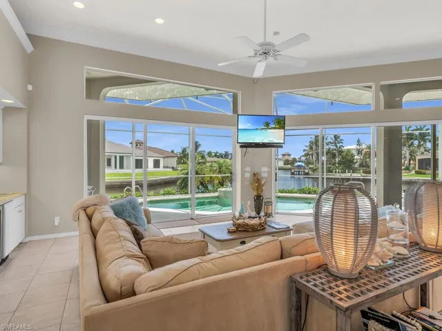 Tiled living room with a water view, ceiling fan, and a wealth of natural light