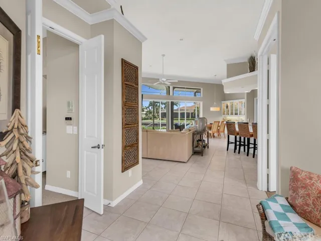 Hall with crown molding and light tile patterned floors