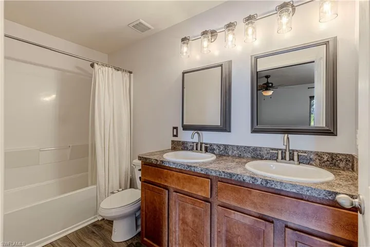 MASTER Full bath featuring double vanity, shower / bath combo with shower curtain, and wood finished floors