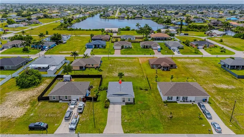 Aerial perspective of suburban area featuring a nearby body of water