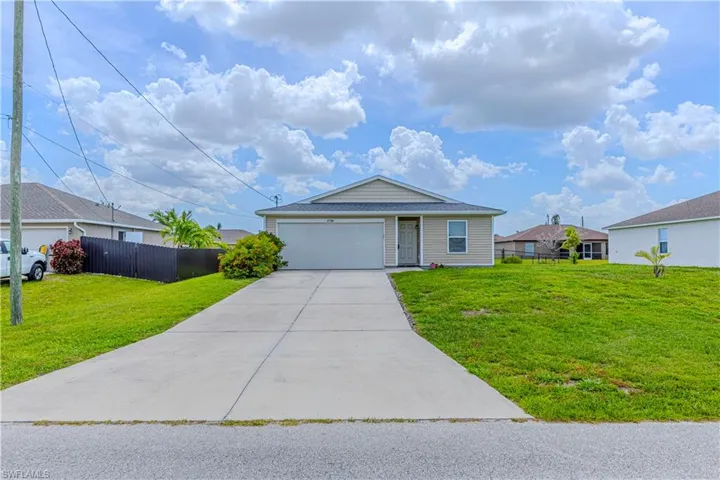 Single story home with concrete driveway and a garage
