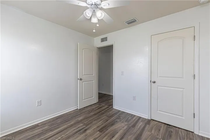 Unfurnished bedroom with dark wood-type flooring and ceiling fan