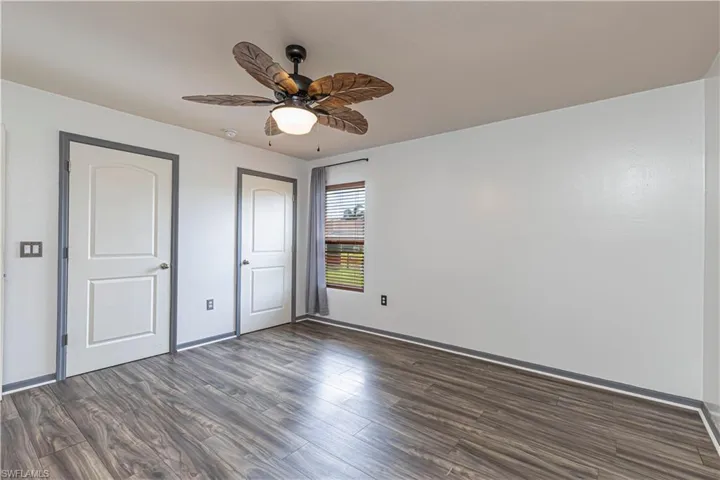 Unfurnished bedroom featuring dark wood finished floors and a ceiling fan