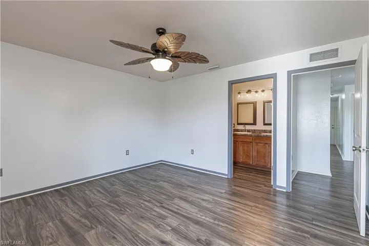 Empty room featuring dark wood finished floors and ceiling fan