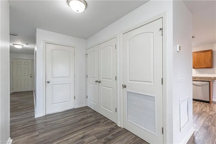 GARAGE ENTRANCE/FOYER/LAUNDRY ROOM DOOR/Hallway with dark wood-style floors and baseboards