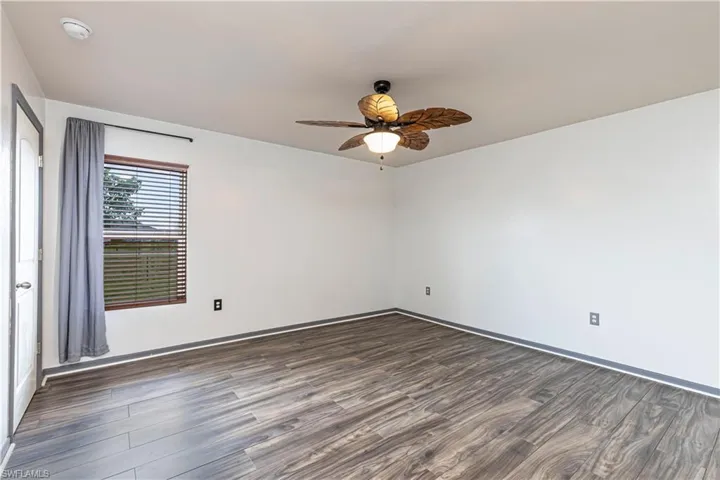 Spare room featuring dark wood-style floors and a ceiling fan