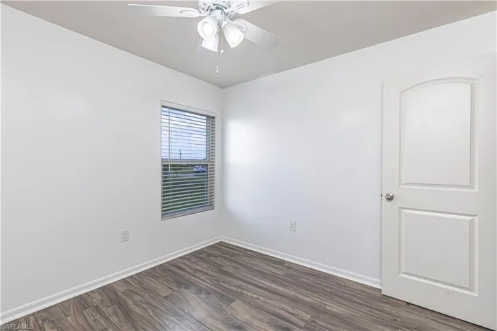 Unfurnished room with dark wood-style floors and a ceiling fan