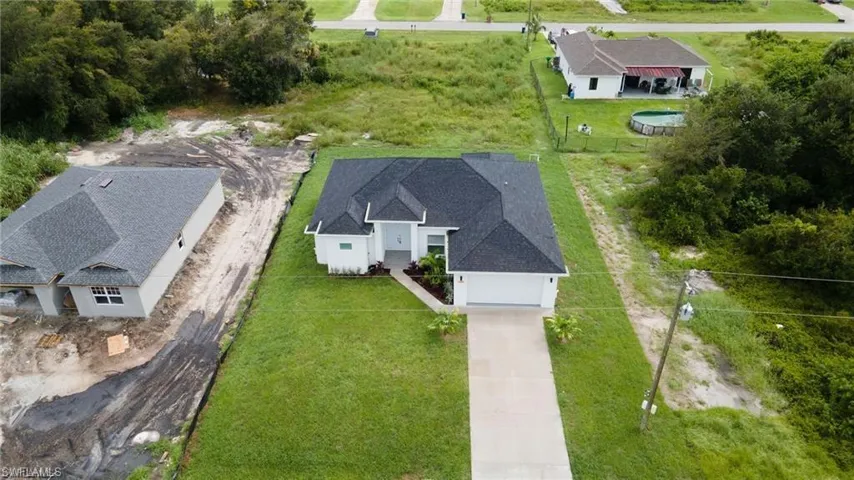 Newly constructed single-story residence featuring a dark shingle roof and white exterior siding