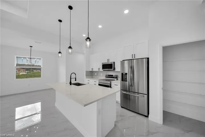 Modern kitchen island featuring a rectangular undermount sink and matte black faucet