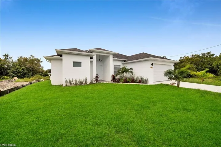 Contemporary white stucco exterior with a dark shingled roof, an attached two-car garage, and a concrete driveway