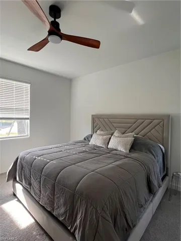Carpeted bedroom with baseboards and ceiling fan