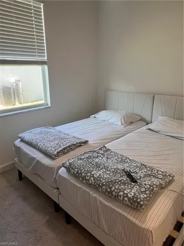 Bedroom featuring carpet flooring and baseboards