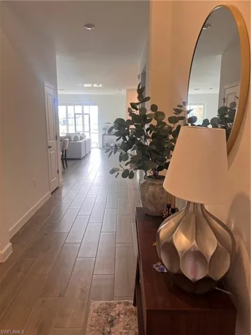 Hallway with wood finished floors and healthy amount of natural light
