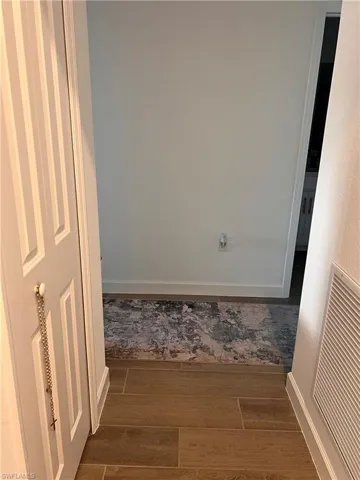 Corridor with wood finished floors and baseboards