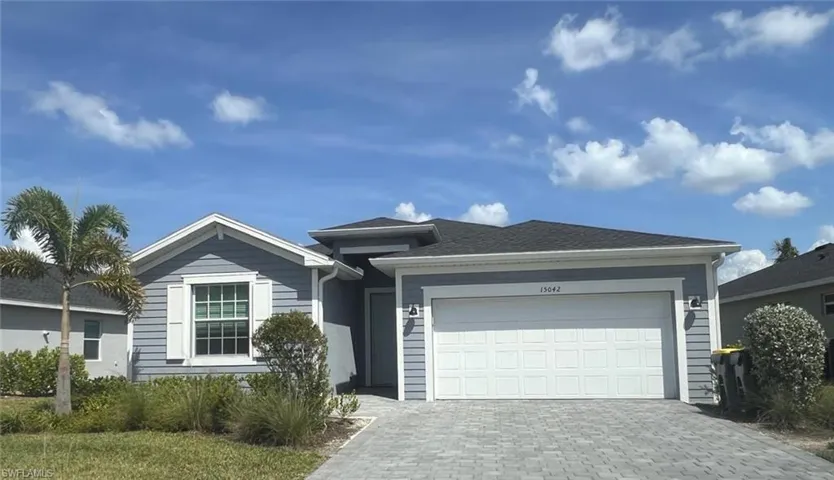 Ranch-style home featuring decorative driveway and a garage