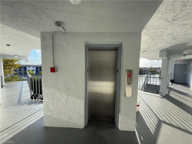 View of exterior entry with elevator and stucco siding